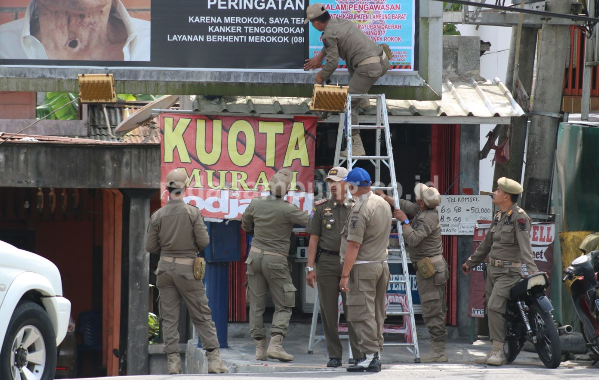 Pol PP Lambar Copot dan Segel Baliho Iklan Rokok