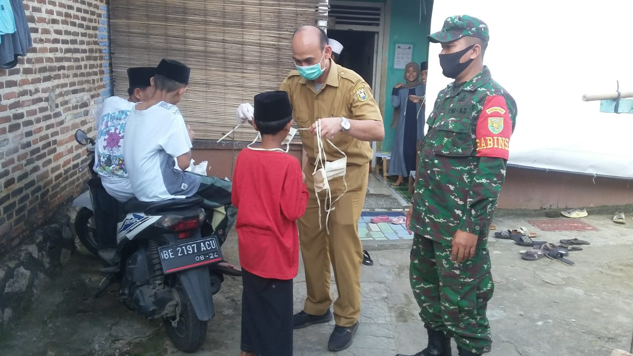 Babinsa Sumur Batu Bersama Pegawai BPKAD Bagikan Masker Kepada Warga